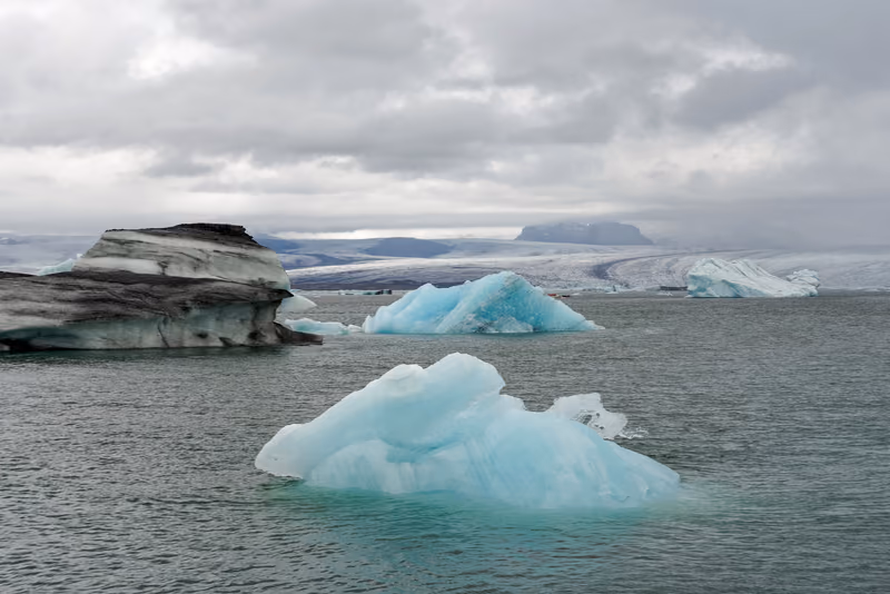 Pale blue icebergs on the grey water of Jökulsárlón glacier lagoon